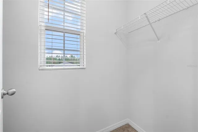 a bedroom with a bed and a flat tv screen next to a window