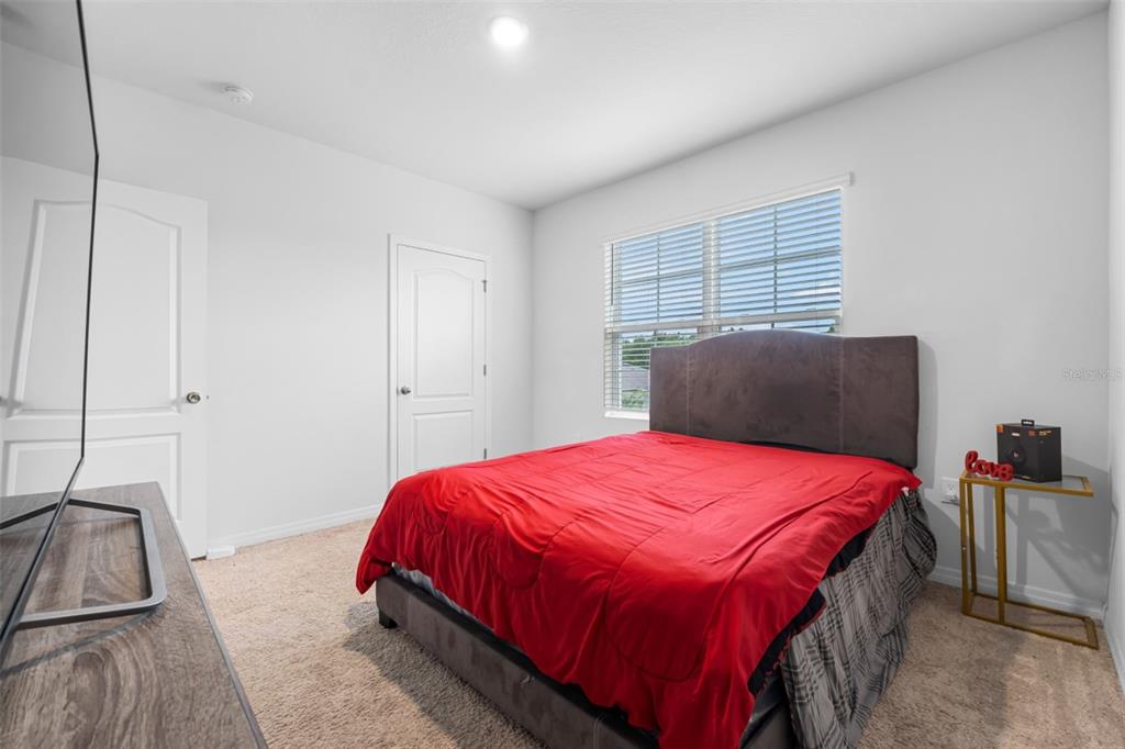 821 Sun Burst Road Winter Haven, FL 33880 - Photo 66 of 86 a bedroom with a bed and a flat tv screen next to a window