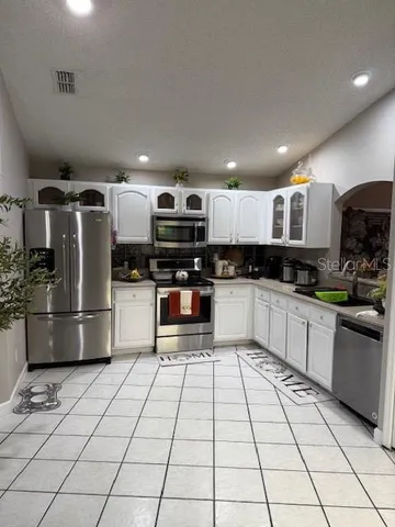 a kitchen with stainless steel appliances granite countertop a refrigerator sink a microwave and cabinets