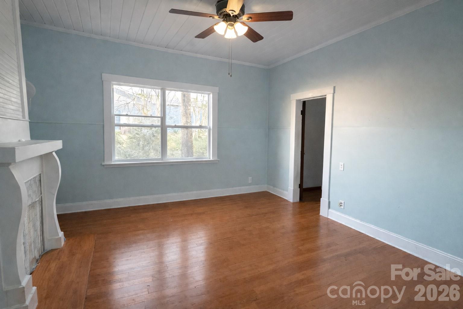 129 11th Street Spencer, NC 28159 - Photo 9 of 22 a view of an empty room with wooden floor and a window