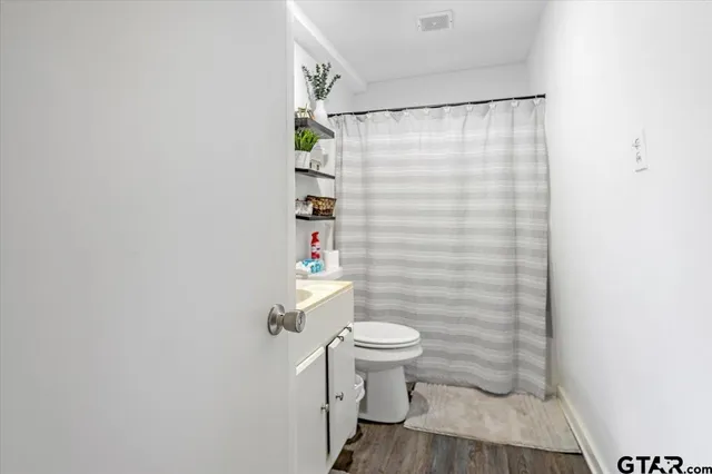 a bathroom with a toilet and a shower curtain
