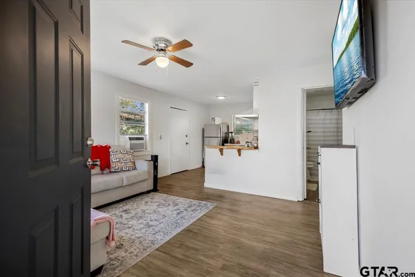 a view of a livingroom with wooden floor and a ceiling fan