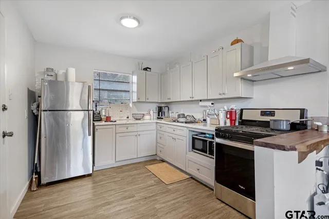 a kitchen with a white cabinets and wooden floor