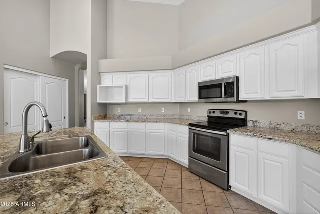 a kitchen with stainless steel appliances granite countertop a sink and a stove