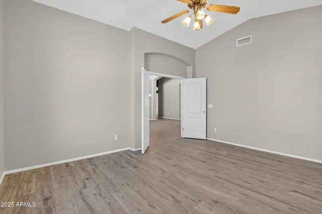 wooden floor in an empty room with a fan