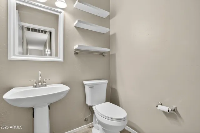 a bathroom with a toilet sink and mirror