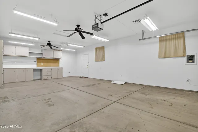 an empty room with ceiling fan and wooden floor