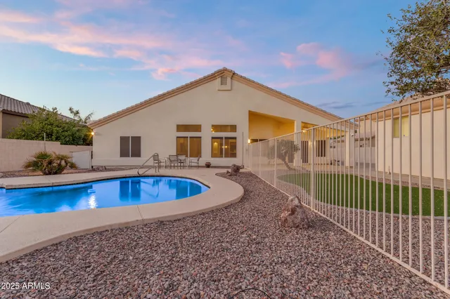 a view of a house with a swimming pool and sitting area
