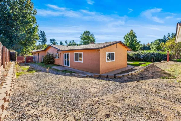 a view of a house with backyard and trees