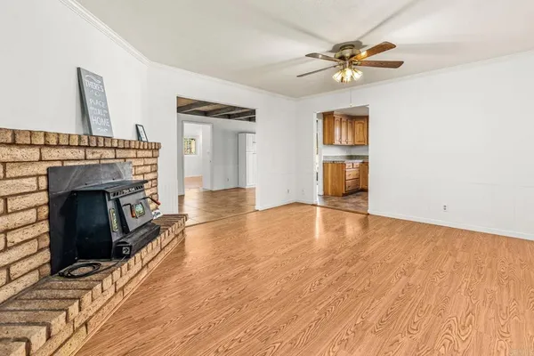 a view of empty room with a fireplace and wooden floor