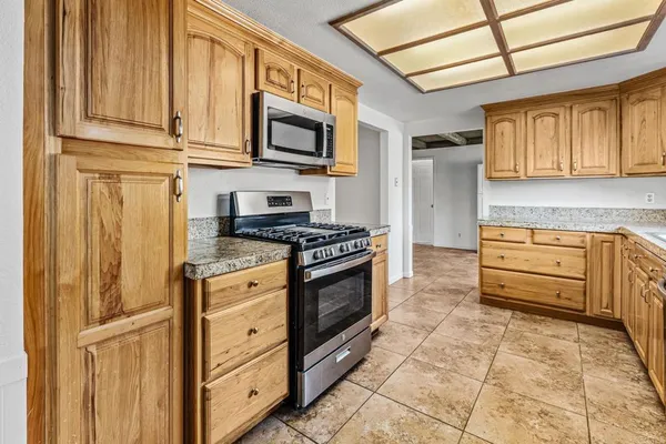 a kitchen with stainless steel appliances granite countertop a stove a microwave and a refrigerator