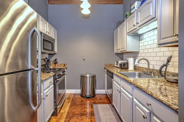 a kitchen with stainless steel appliances granite countertop a stove microwave and refrigerator