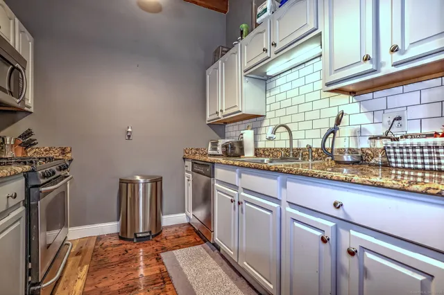 a kitchen with granite countertop lots of counter top space and wooden floor