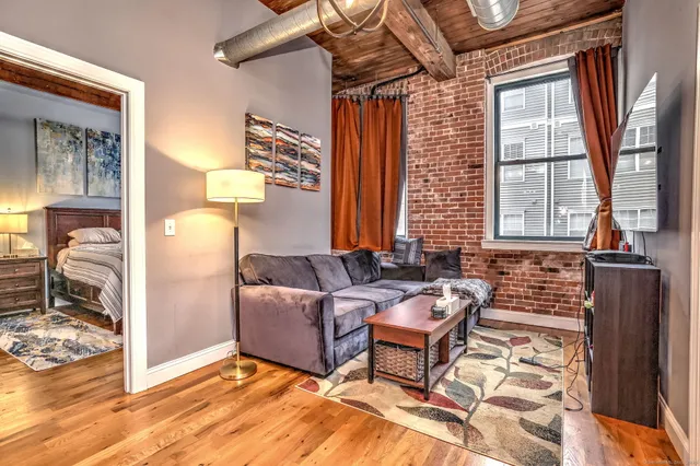 a bedroom with a bed and a dresser next to a window