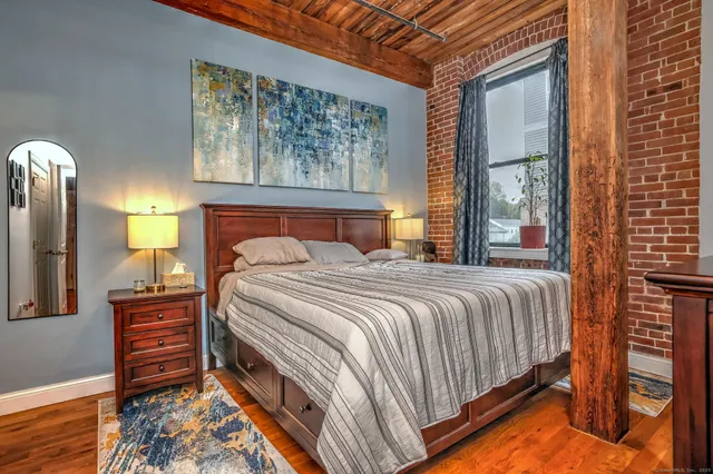 a bedroom with a bed and a painting on the wall