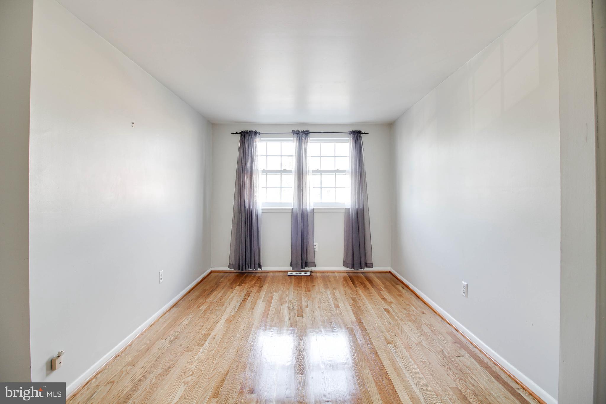5649 Chelwynd Road Halethorpe, MD 21227 - Photo 18 of 44 wooden floor in an empty room with a window