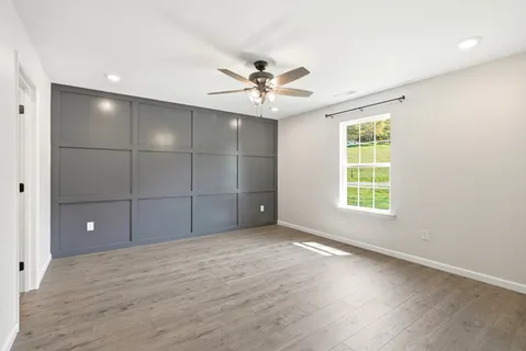 an empty room with fan and windows