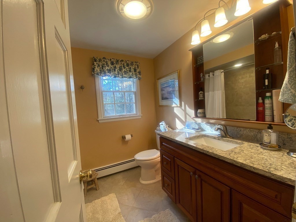 126 Maynard Farm Road Sudbury, MA 01776 - Photo 24 of 32 a bathroom with a granite countertop sink a toilet a mirror and shower