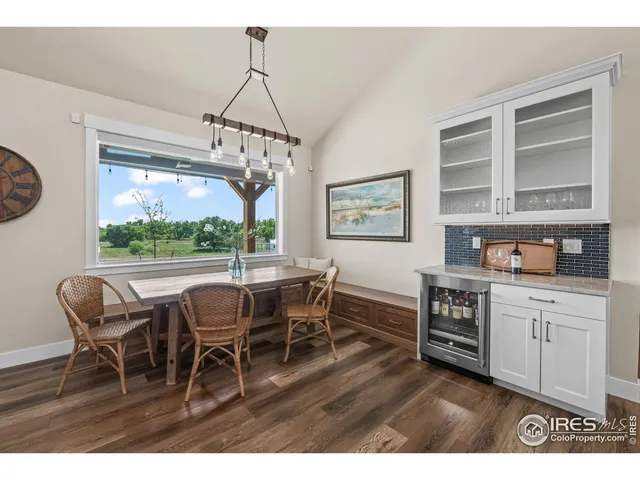 a living room with furniture kitchen view and a wooden floor