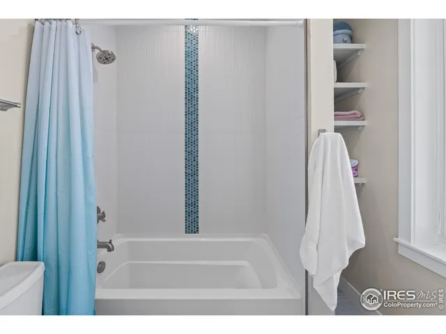 a view of a livingroom with furniture wooden floor a ceiling fan and windows