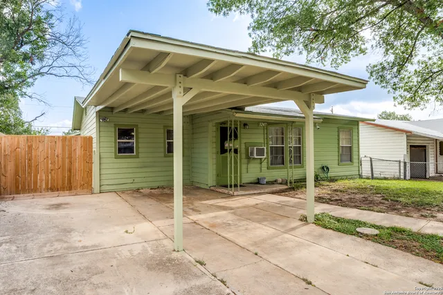 a view of a house with backyard and sitting area