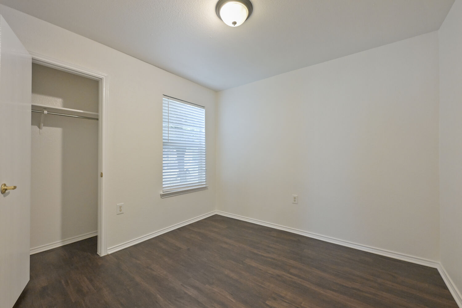 6733 Doyal Drive Austin, TX 78747 - Photo 15 of 28 A well-proportioned room with dark wood flooring and ample natural light from the window.