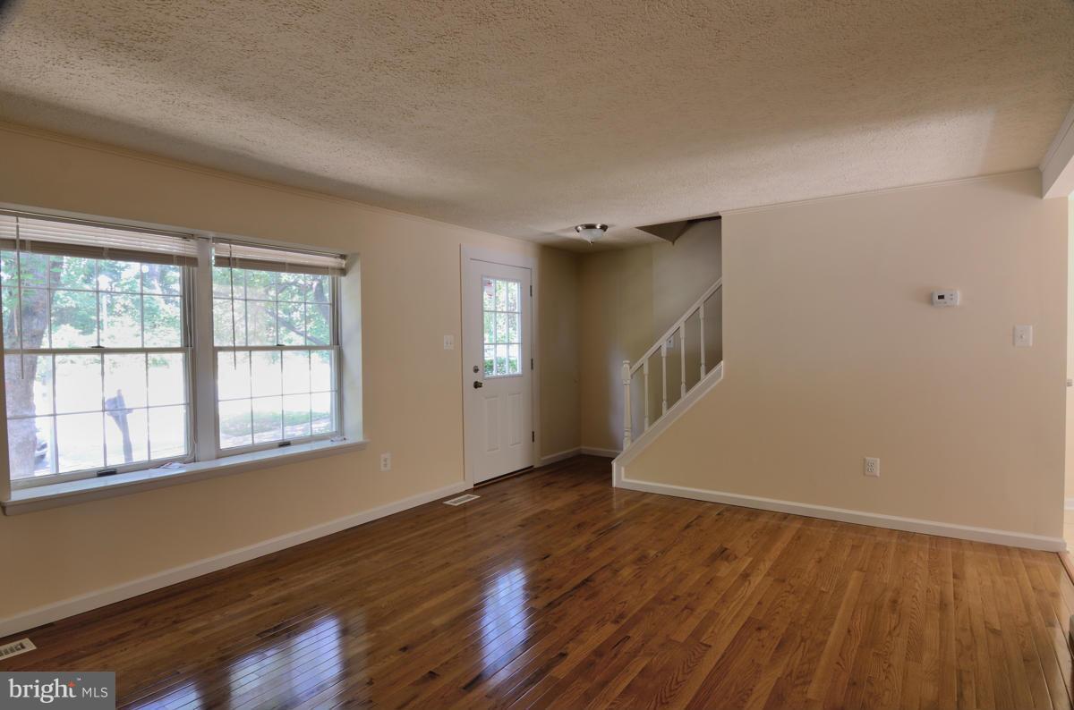 10334 Apple Ridge Road Gaithersburg, MD 20886 - Photo 2 of 18 a view of an empty room with wooden floor and a window