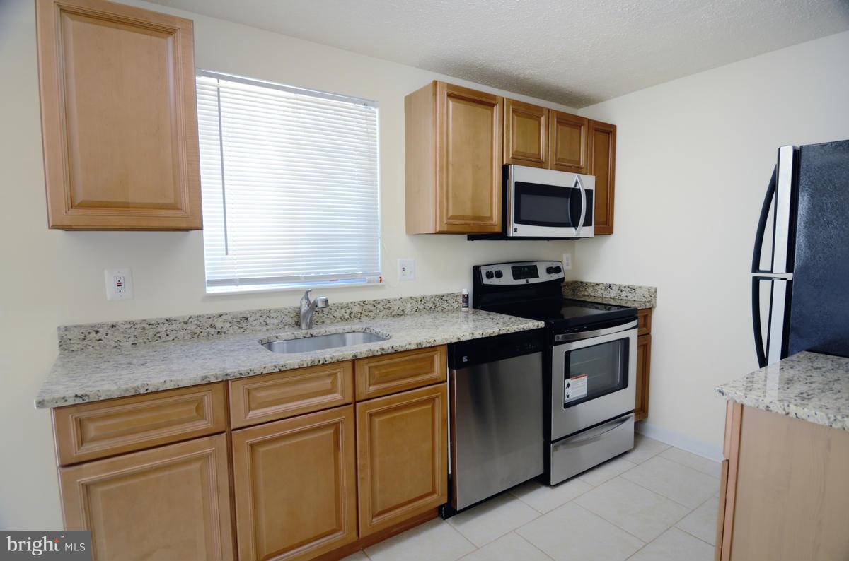 10334 Apple Ridge Road Gaithersburg, MD 20886 - Photo 5 of 18 a kitchen with granite countertop a sink stove and microwave