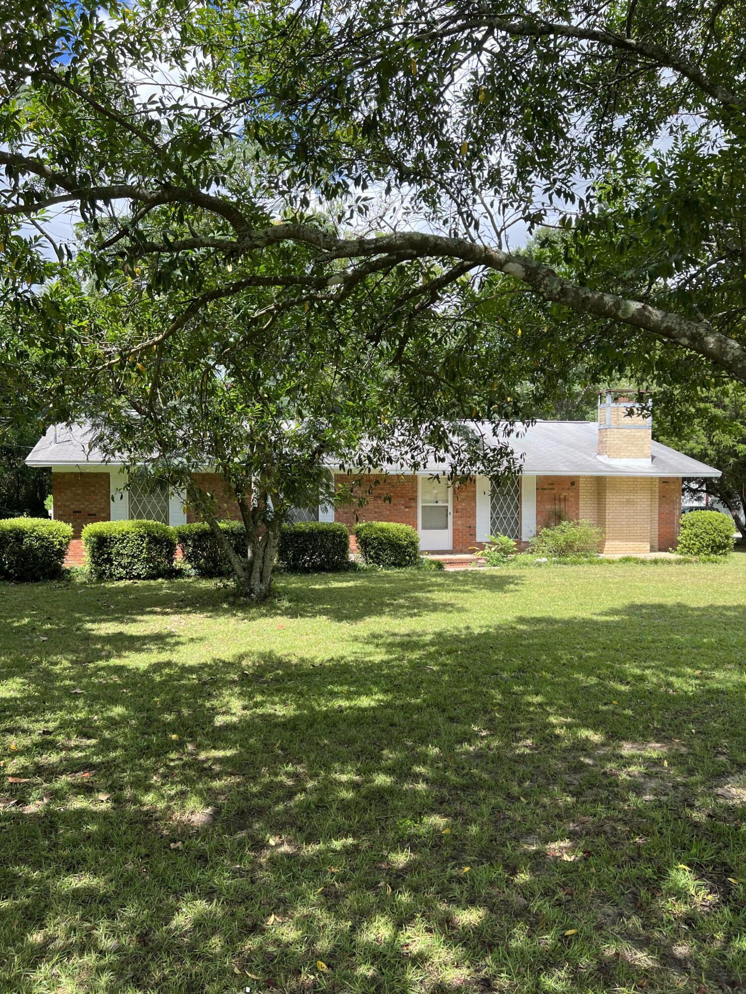 3693 Airport Road Crestview, FL 32539 - Photo 1 of 18 a front view of a house with a garden