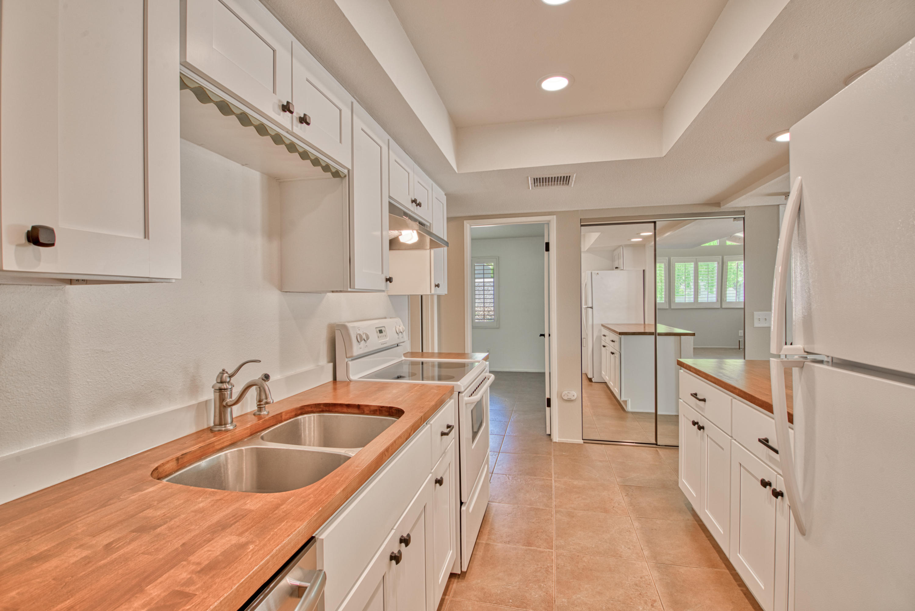 3518 Ridgeview Circle South Palm Springs, CA 92264 - Photo 17 of 32 a large white kitchen with double vanity sink and dishwasher