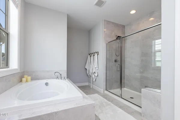 a bathroom with a white bath tub a shower and a sink