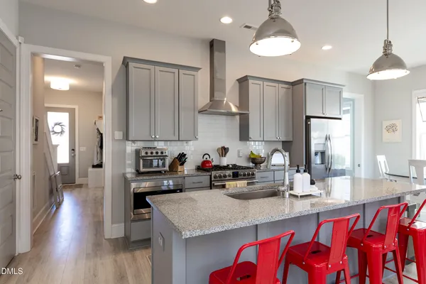 a kitchen with stainless steel appliances granite countertop a sink refrigerator and cabinets