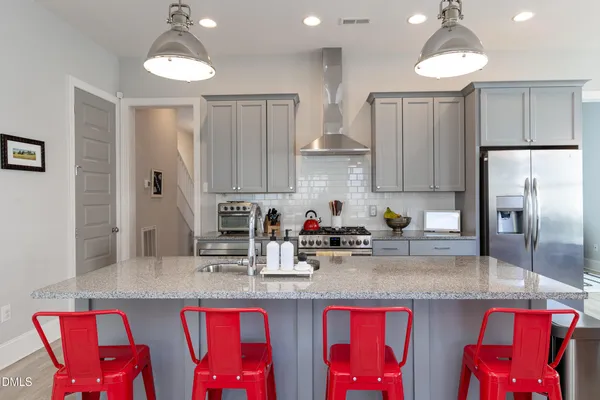 a kitchen with stainless steel appliances granite countertop a sink and refrigerator