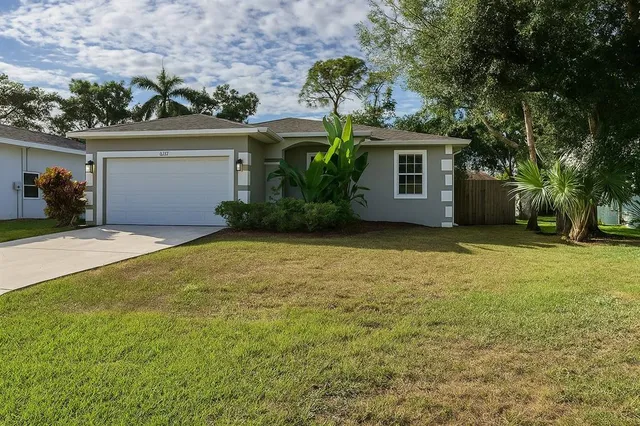 a view of a house with a yard and garage