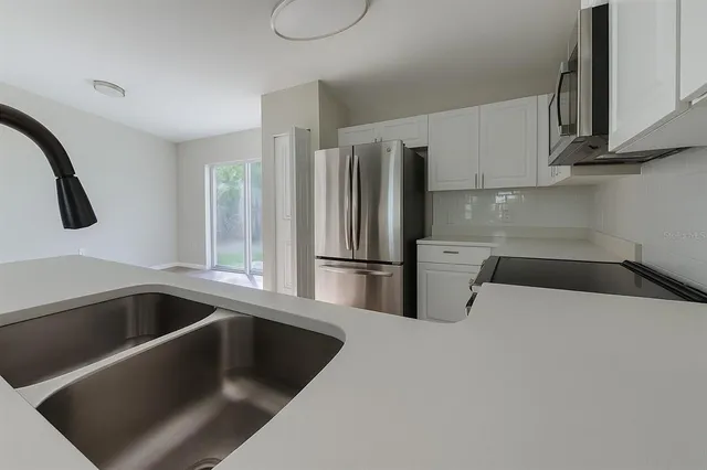 a kitchen with a refrigerator sink and cabinets