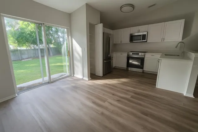 a kitchen with stainless steel appliances a refrigerator sink and microwave