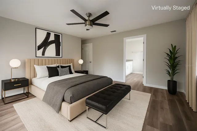 a bedroom with a large bed and a potted plant