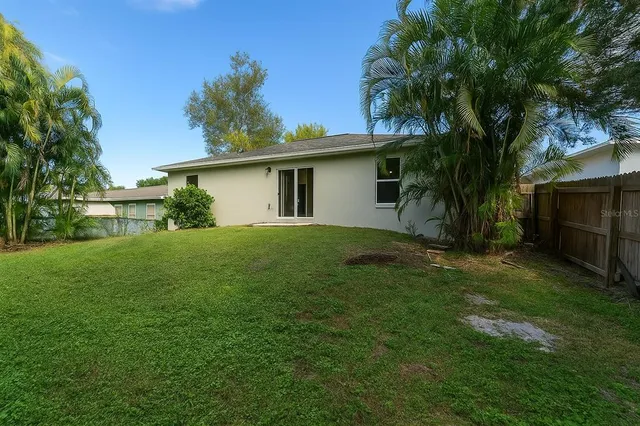 a backyard of a house with table and chairs