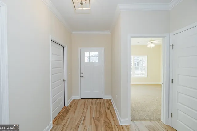 a view of a hallway with wooden floor and a bathroom