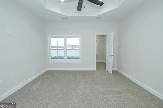 an empty room with glass door and chandelier fan