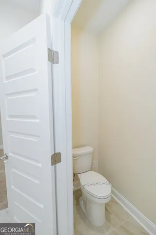 a white toilet sitting next to a shower
