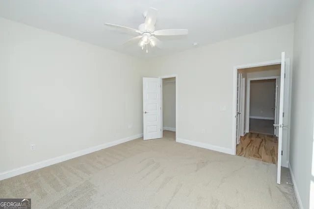 an empty room with fan and entrance