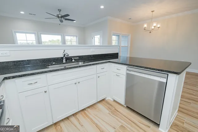 a kitchen with granite countertop white cabinets and white appliances