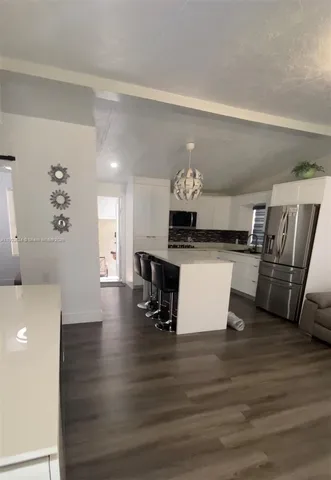 a kitchen with stainless steel appliances a stove a table and a refrigerator