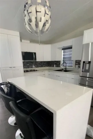 a kitchen with a sink a stove and chairs