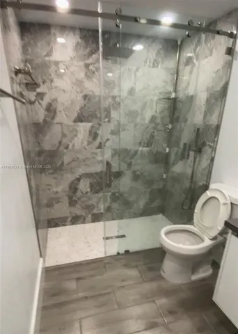 a bathroom with a toilet and a shower