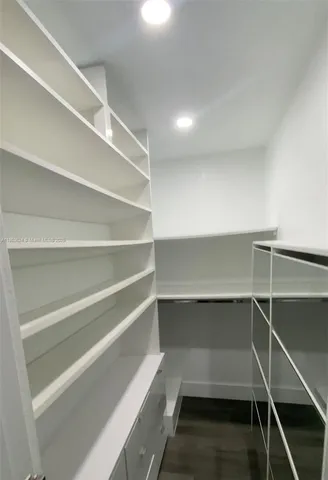 a view of walk in closet with empty racks
