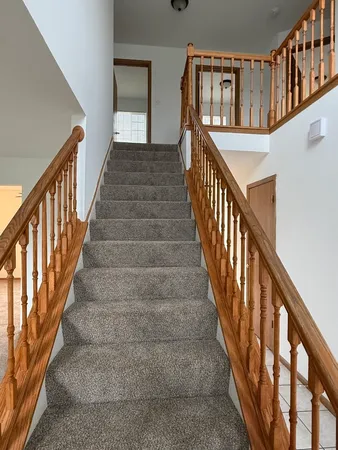 a view of staircase with lots of frames on wall and wooden floor