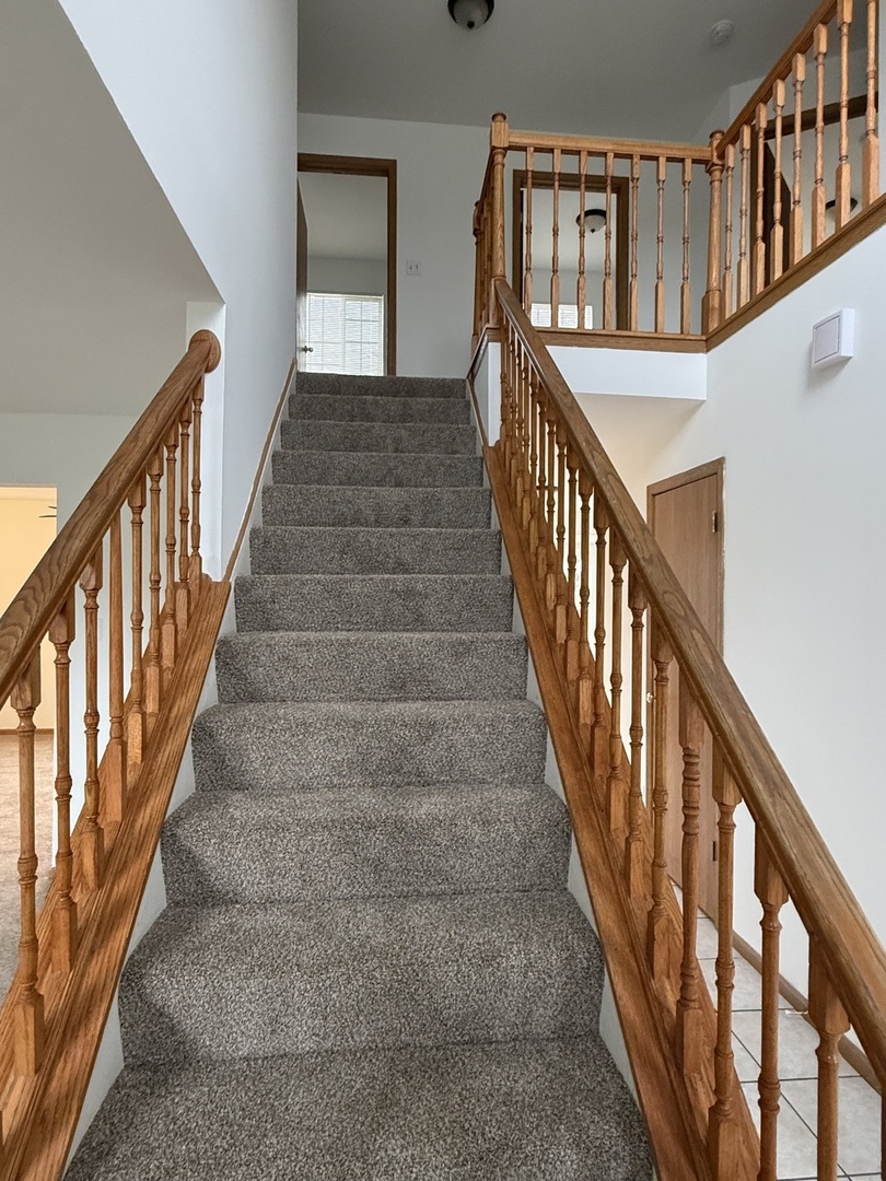 1004 Ann Street Joliet, IL 60435 - Photo 13 of 33 a view of staircase with lots of frames on wall and wooden floor