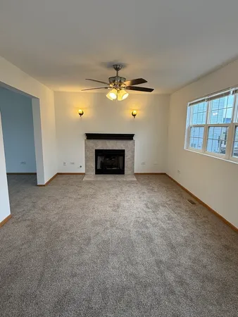 an empty room with windows and fireplace